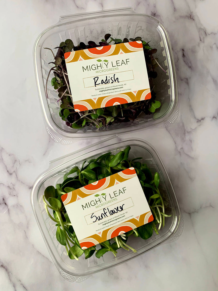 Containers of organic radish and sunflower microgreens with a Mighty Leaf Microgreens label.